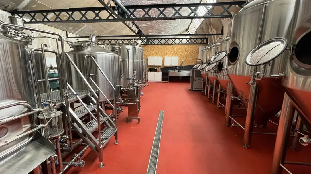 La salle de brassage : cuves inox et sol rouge